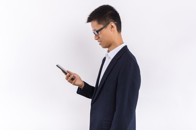 A young business male is using a mobile phone