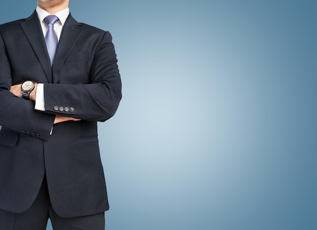 Young business man in black suit on blue background