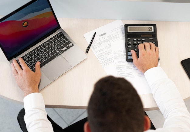 Young business man in costume working in an office accountant