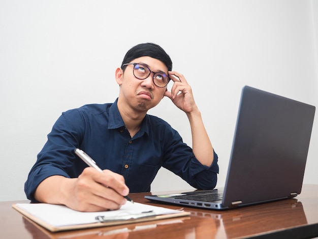 Il giovane uomo d'affari si sente annoiato a lavorare seduto al tavolo del posto di lavoro