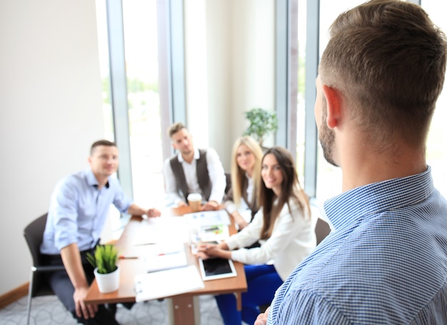 Young business man giving a presentation at a meeting seminar at modern conference room