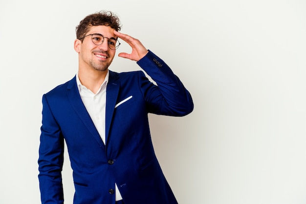 Young business man isolated on white wall laughing happy, carefree, natural emotion