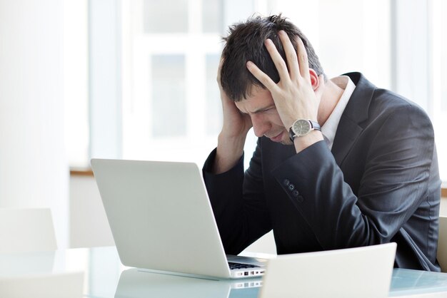 young business man lawyer with laptop alone in big bright   conference room