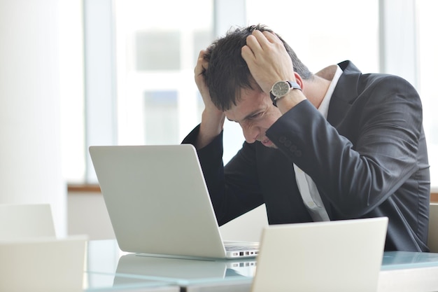 Photo young business man lawyer with laptop alone in big bright   conference room