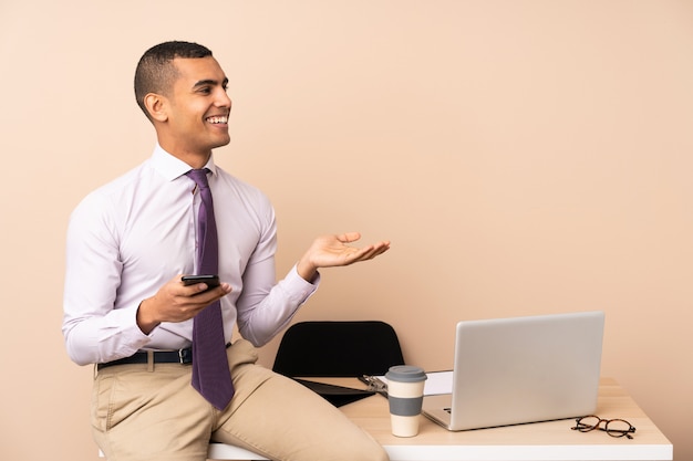 Young business man in a office extending hands to the side for inviting to come