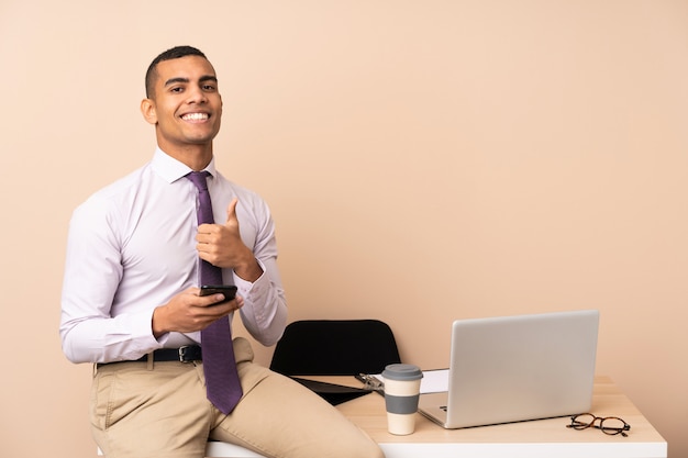 Young business man in a office giving a thumbs up gesture