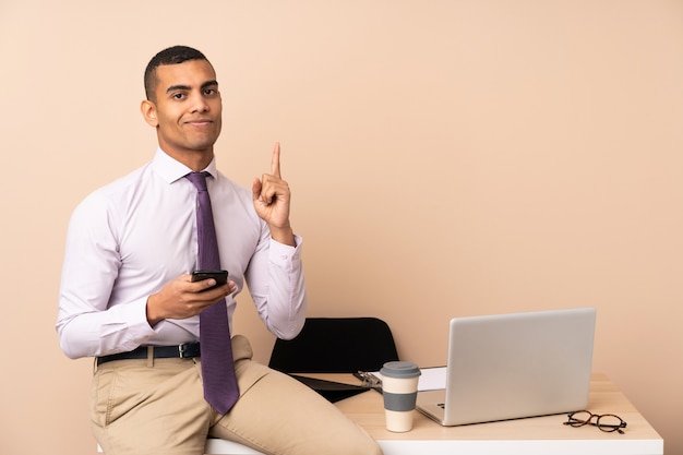 Young business man in a office pointing with the index finger a great idea