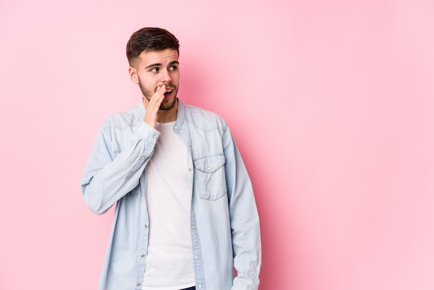 Young business man posing is saying a secret hot braking news and looking aside