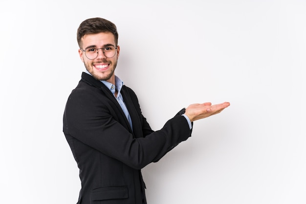 Young business man posing in a white wall isolated Young business man holding a copy space on a palm