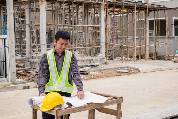 Young business man professional engineer worker at the house building construction site with blueprint