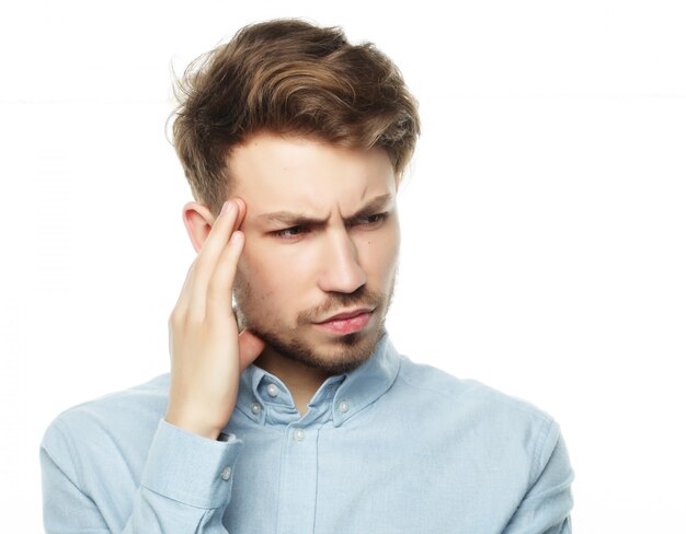 Young business man touching his head and keeping eyes closed