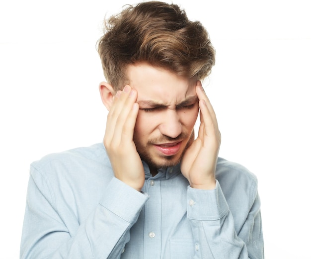 Young business man touching his head and keeping eyes closed