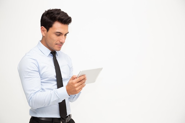 Молодой деловой человек с помощью планшета под рукой, изолированные на белом фоне