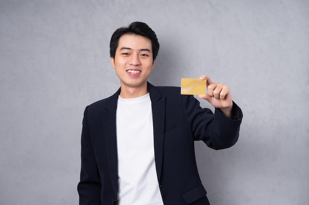 Young business man wearing a suit posing on a grey background