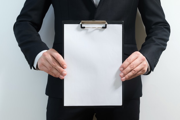 Young business man wearing a suit while holding sign board.