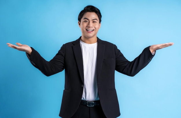 Young business man wearing a vest posing on a blue background