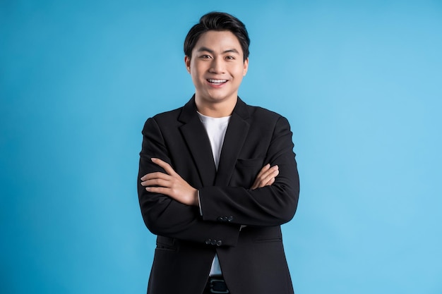 Young business man wearing a vest posing on a blue background