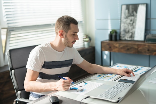 Young business man working on a laptop at his desk in the office