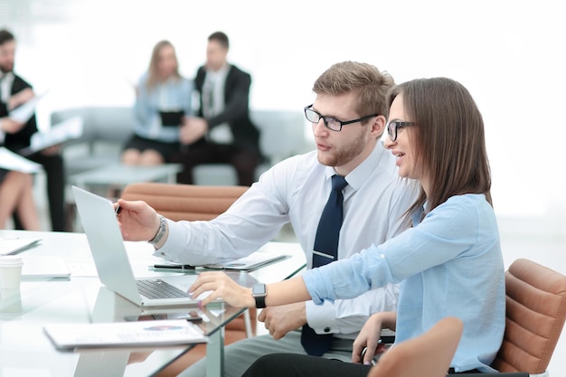 Young business man working together with her colleague on laptop in office