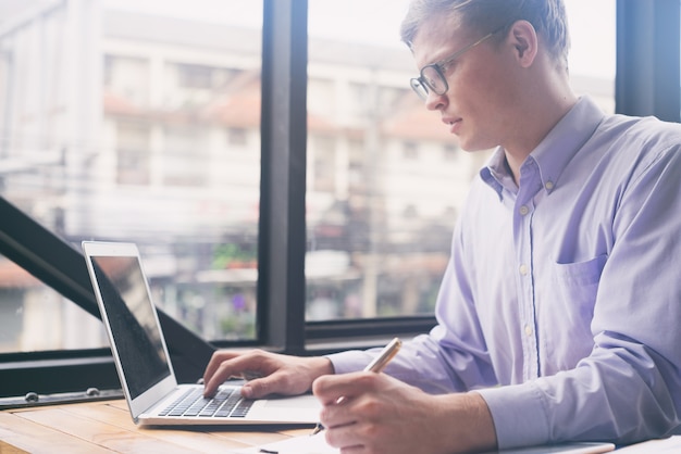 young business man working with mobile laptop and documentsin office, business concept