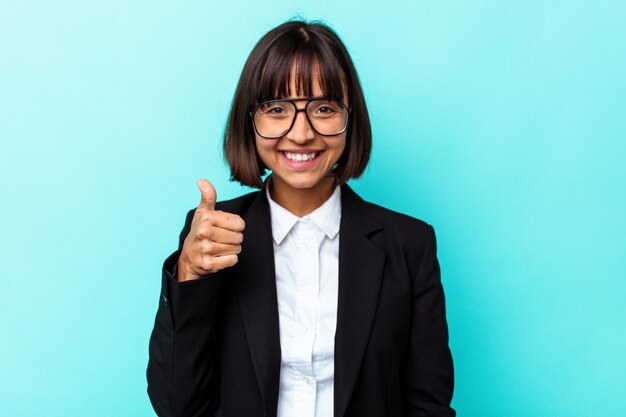 Young business mixed race woman isolated on blue background smiling and raising thumb up