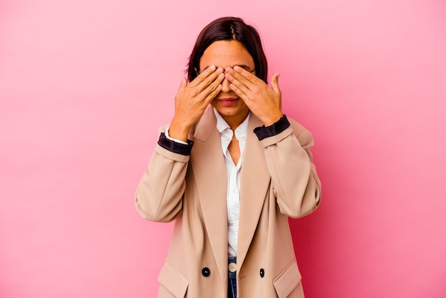 Young business razza mista donna isolata su sfondo rosa paura che copre gli occhi con le mani.