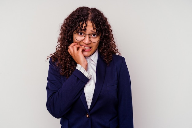 Young business mixed race woman isolated on white biting fingernails, nervous and very anxious.