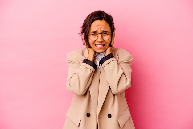 Young business mixed race woman on pink covering ears with hands trying not to hear too loud sound.