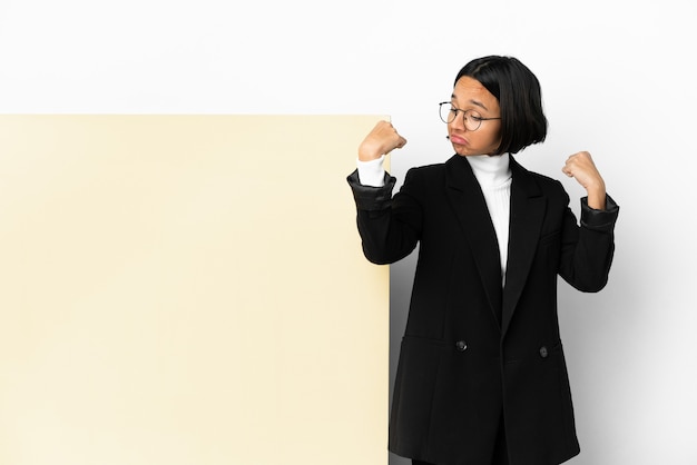 Young business mixed race woman with with a big banner over isolated background doing strong gesture