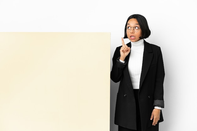 Young business mixed race woman with with a big banner over isolated background thinking an idea pointing the finger up