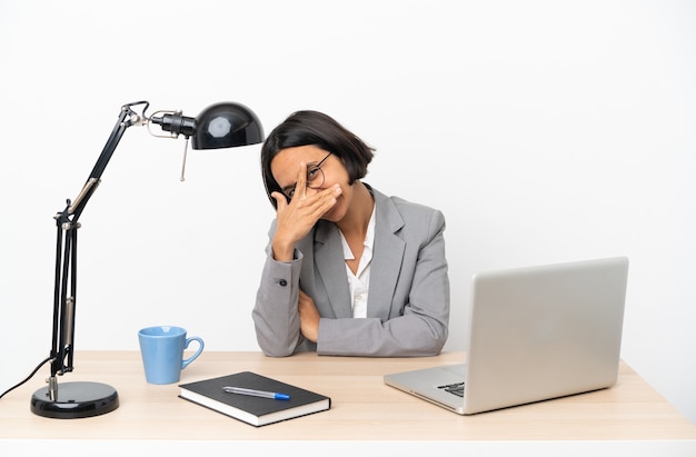 Young business mixed race woman working at office covering eyes by hands and smiling