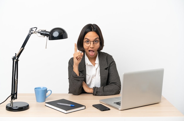 Young business mixed race woman working at office intending to realizes the solution while lifting a finger up