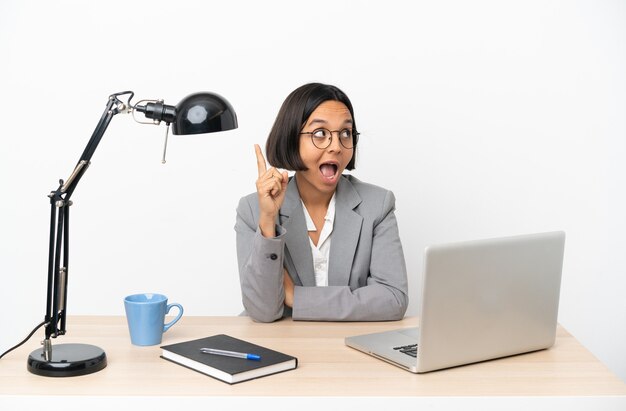 Young business mixed race woman working at office intending to realizes the solution while lifting a finger up