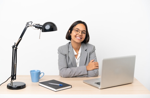 Young business mixed race woman working at office laughing