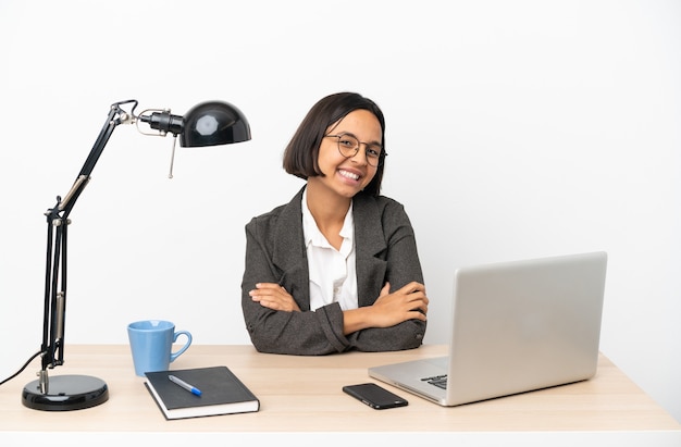 Young business mixed race woman working at office with arms crossed and looking forward