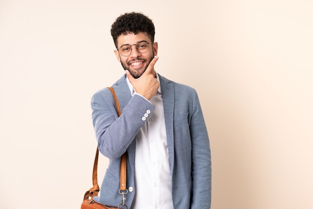 Young business Moroccan man isolated on beige background smiling