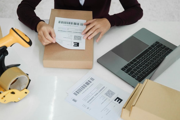 Photo young business owner putting shipping label on parcel