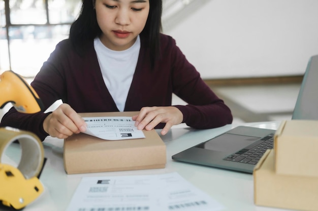 Young business owner putting shipping label on parcel