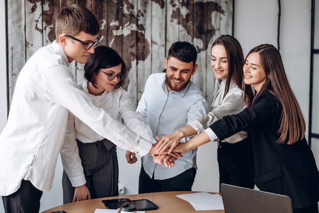 Young business people putting their hands together. Stack of hands. Unity and teamwork concept.