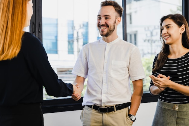 young business people shaking hands in the office finishing successful meeting