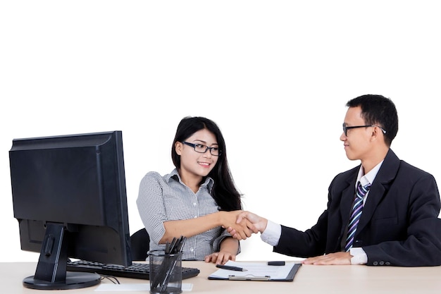 Young business people shaking hands on studio