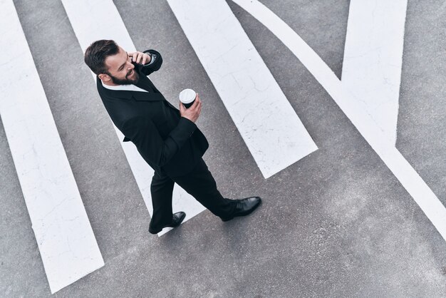 Foto giovane professionista d'impresa. vista dall'alto a figura intera del giovane in abito completo che parla al telefono