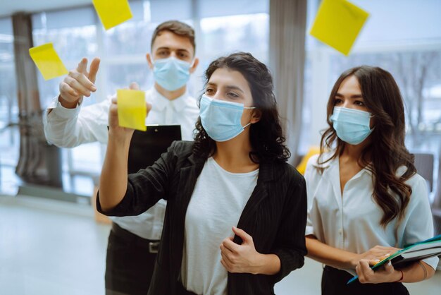 Young business team people in protective face mask on corporate
project together