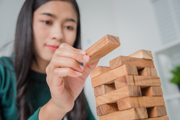 木製のブロックで遊ぶ若いビジネス女性アジア