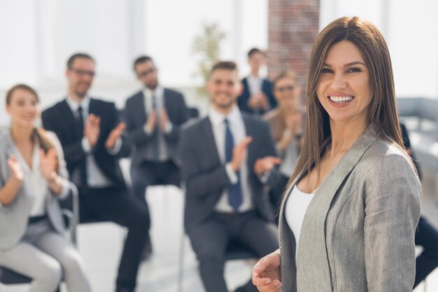 Young business woman on the background of applauding business teamphoto with copy space