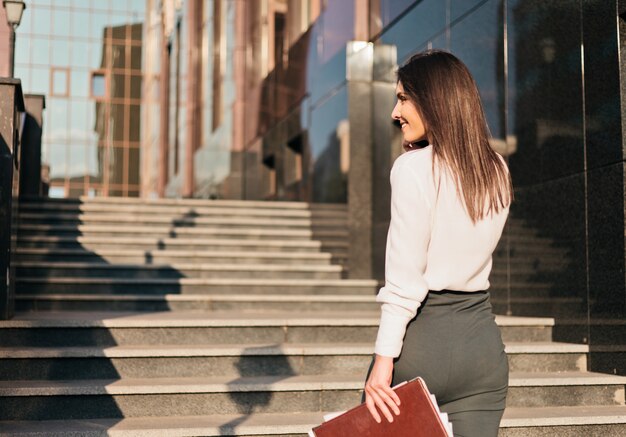 Young business woman in a blouse and a skirt is talking on the phone. 