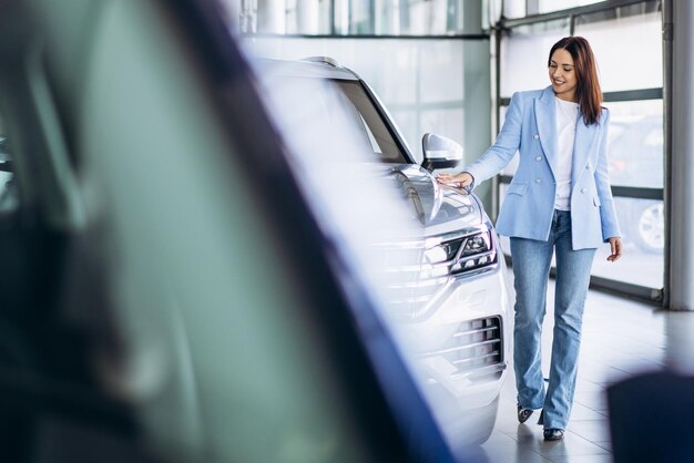 Young business woman choosing a car in a car salon