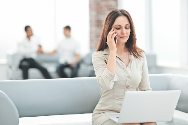 Young business woman communicates with her partners using laptop and smartphone . people and technology