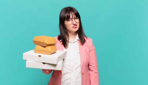 Young business woman feeling puzzled and confused, with a dumb, stunned expression looking at something unexpected