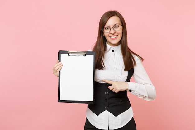 Young business woman in glasses point index finger on clipboard tablet with blank empty sheet workspace copy space isolated on pink background. Lady boss. Achievement career wealth. Advertising area.